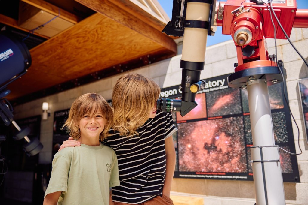 Brothers look through a telescope at the Sunriver Observatory in Sunriver, Oregon