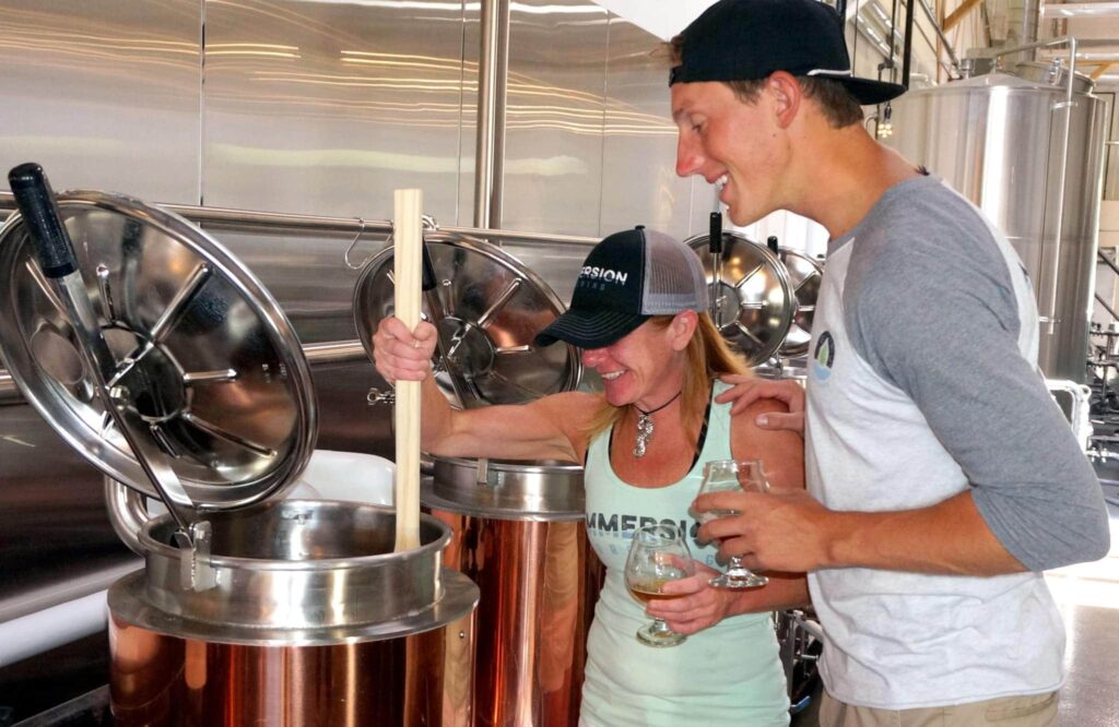 A man and woman stir beer at Immersion Brewing as part of the Brew-it-Yourself program at the Bend, Oregon brewery.