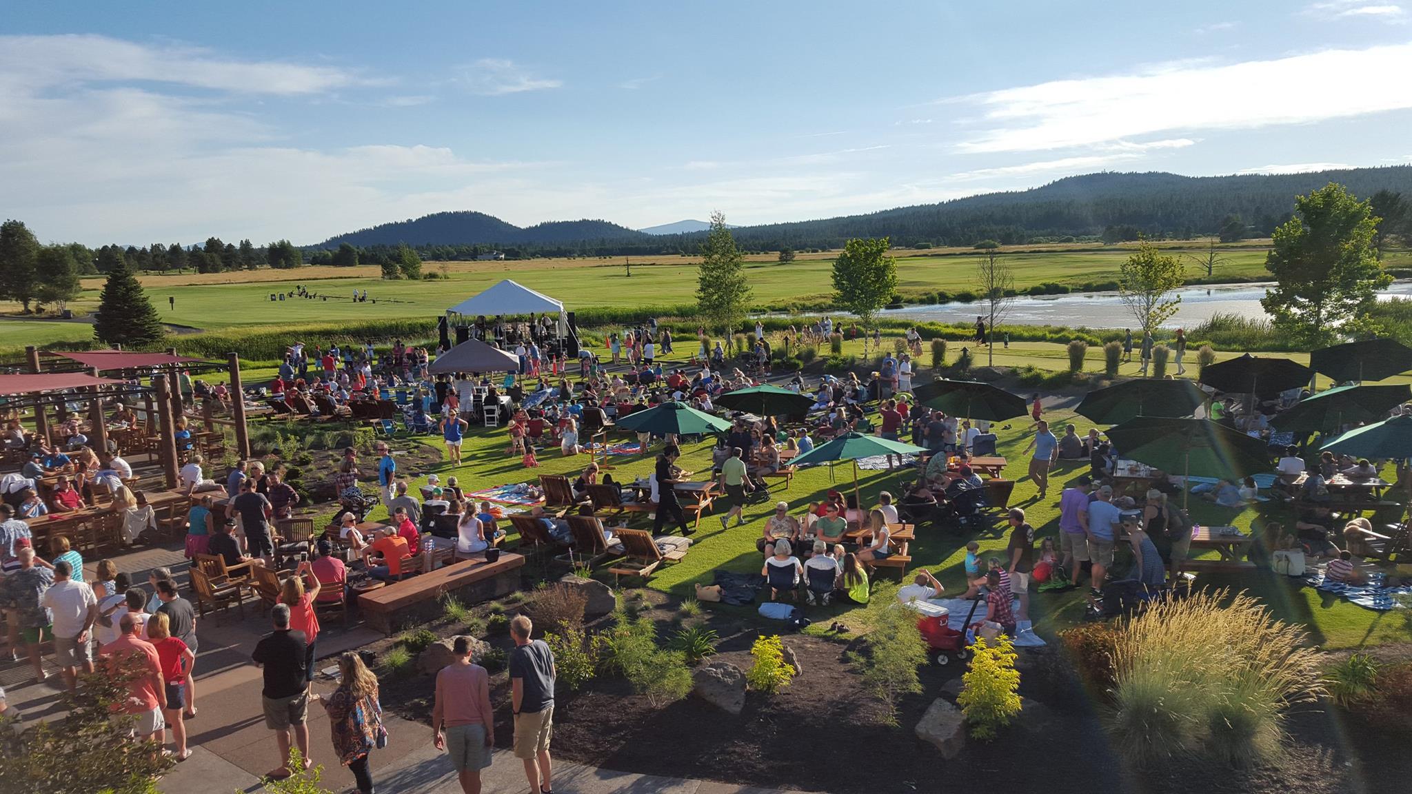 A lively outdoor gathering with people enjoying a sunny day, surrounded by nature in Central Oregon.