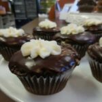 Chocolate cupcakes with white flower icing on top