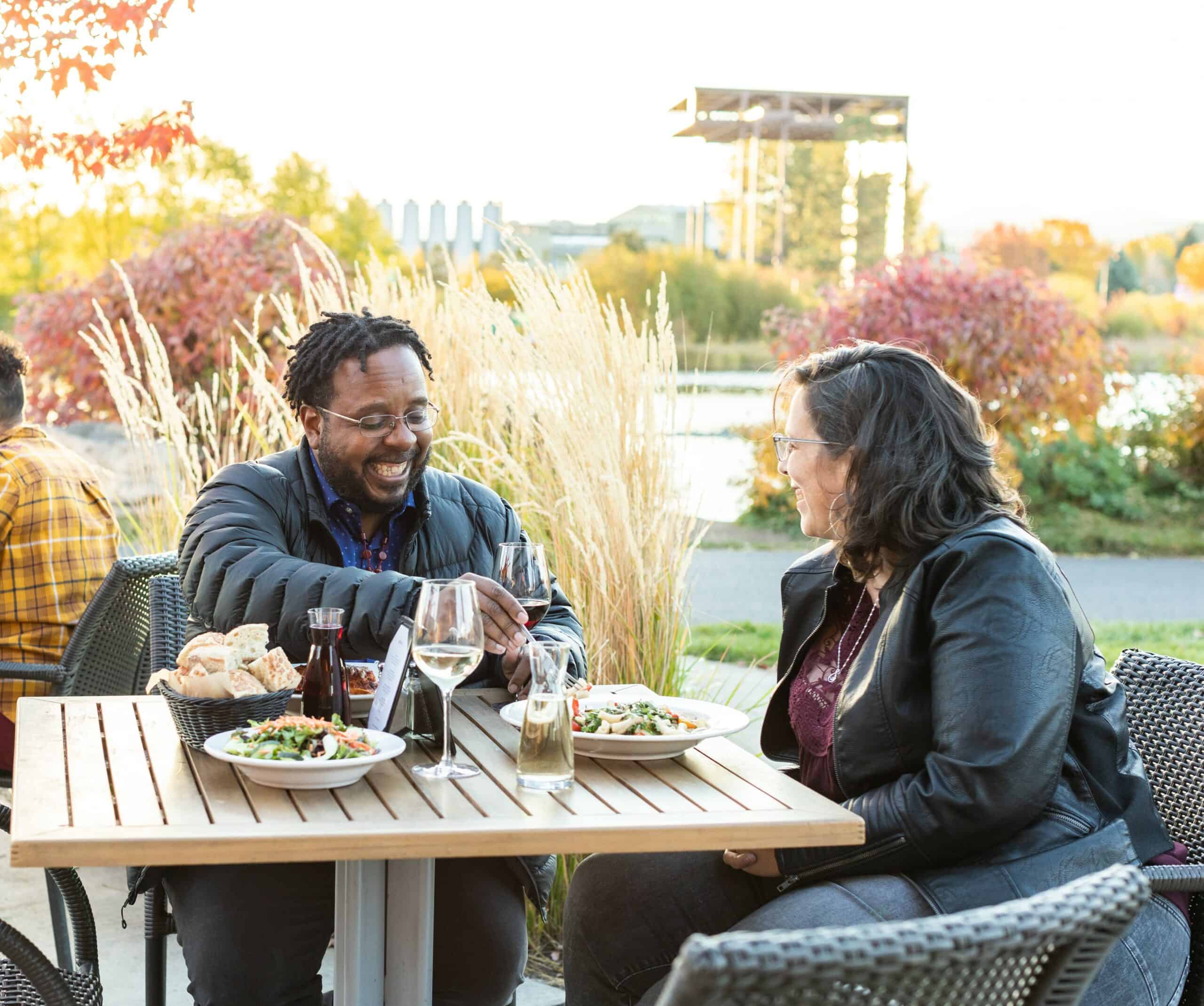 two ladies enjoying wine and apps outside in fall