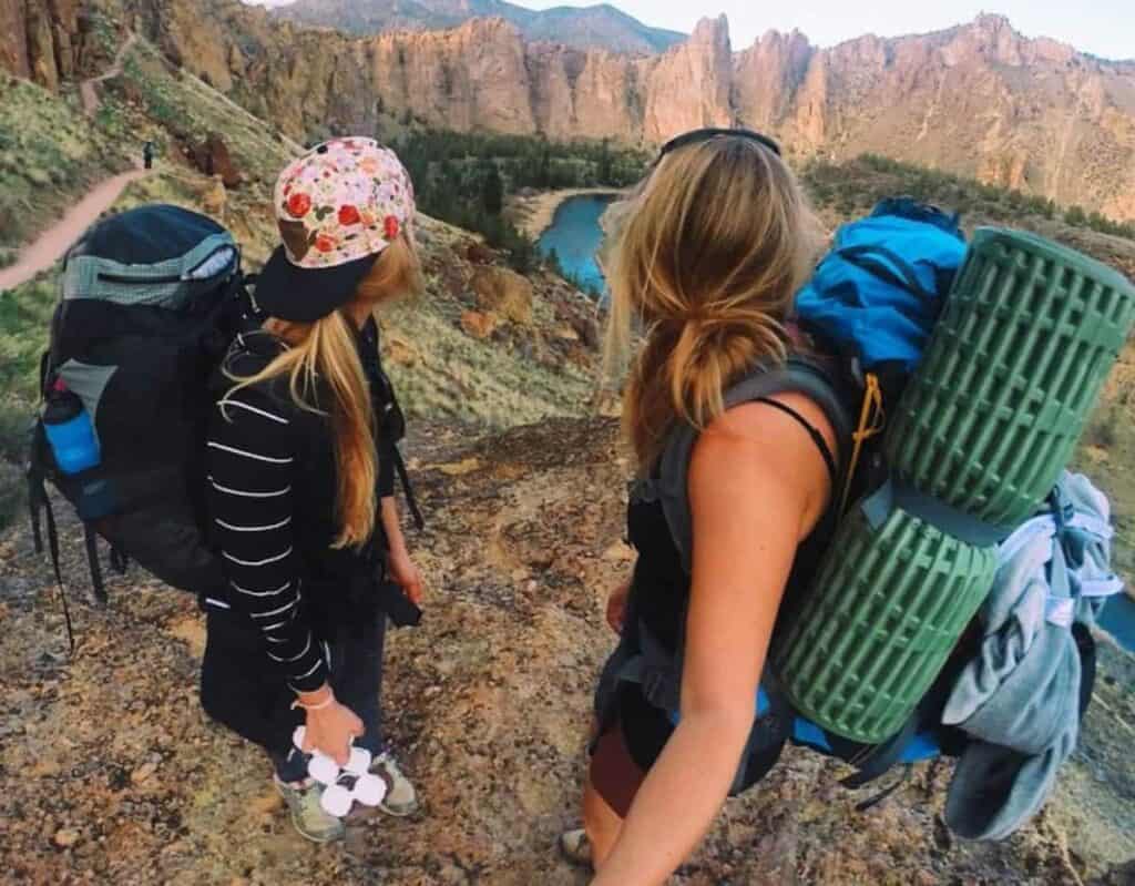 Two hikers explore a scenic trail with backpacks and hiking gear in Central Oregon.