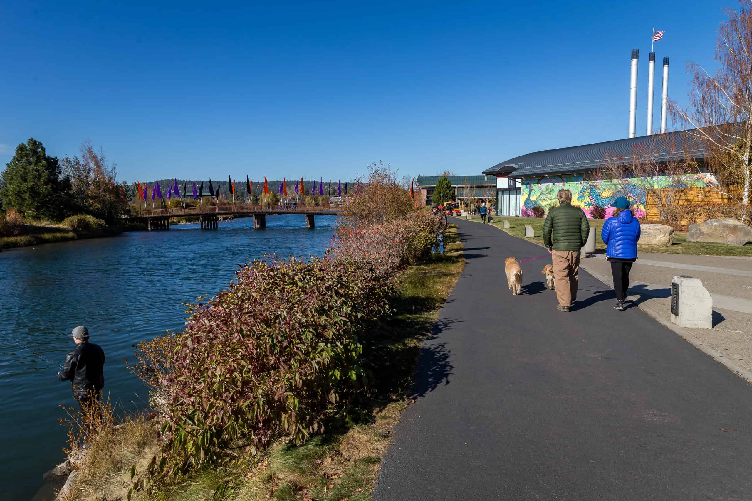 two people taking a walk by the Deschutes River in the old mill 