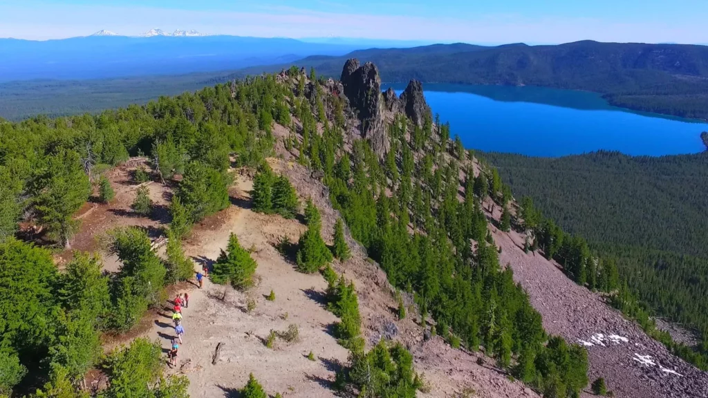 A group of ten people hike to the top of the Newberry Caldera. 