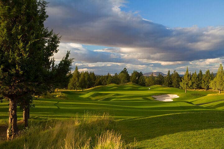 A serene golf course with lush green fairways and strategically placed sand traps in Central Oregon.