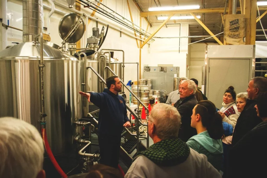 A tour group stands in a brewery.