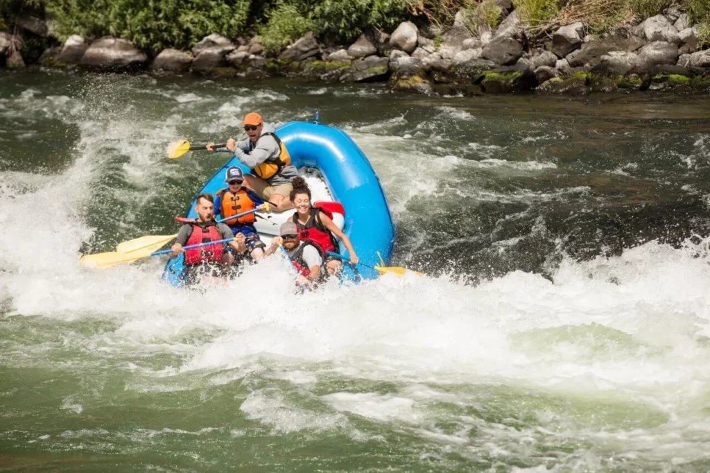 A group of people whitewater rafting down a rapid on the Deschutes River.