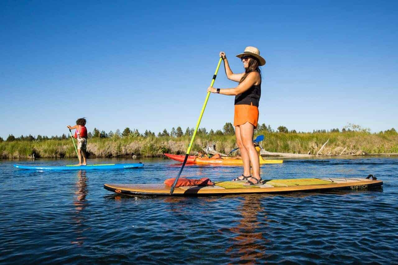 A family paddleboards down the Deschutes River.