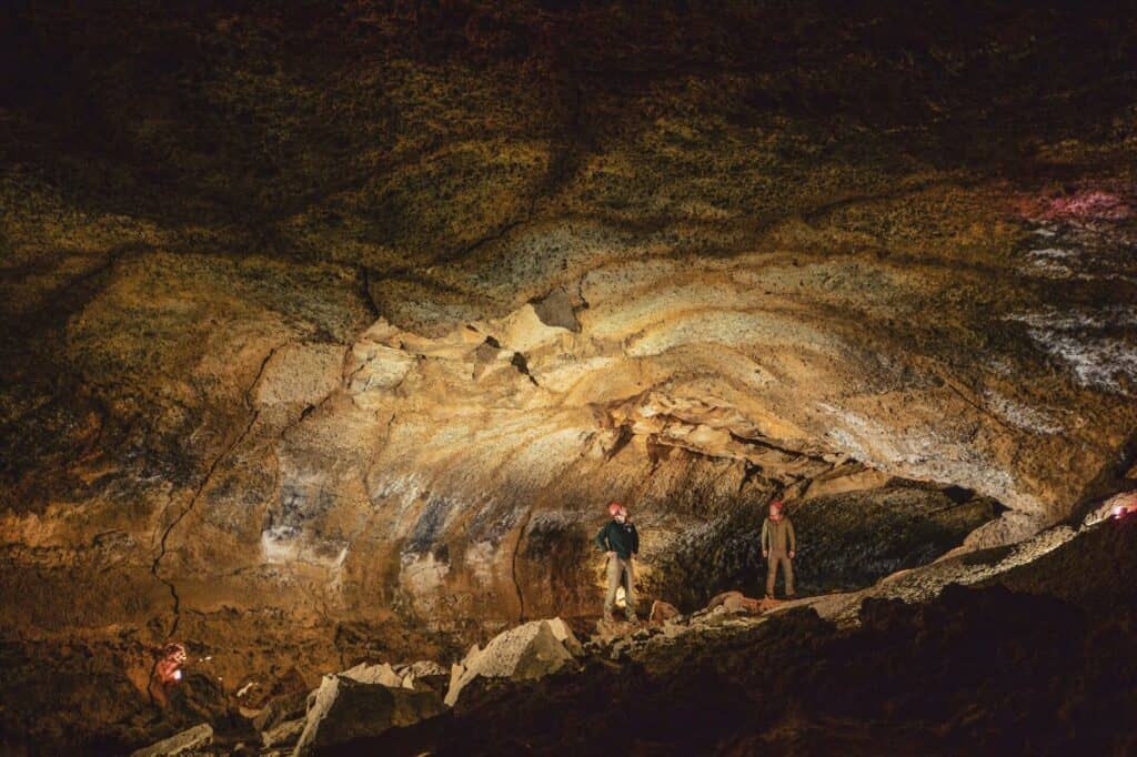 Two people inside a cave in Central Oregon.