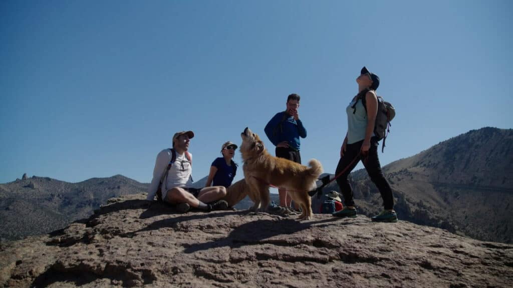 Climbers hang out with a dog at Smith Rock. 