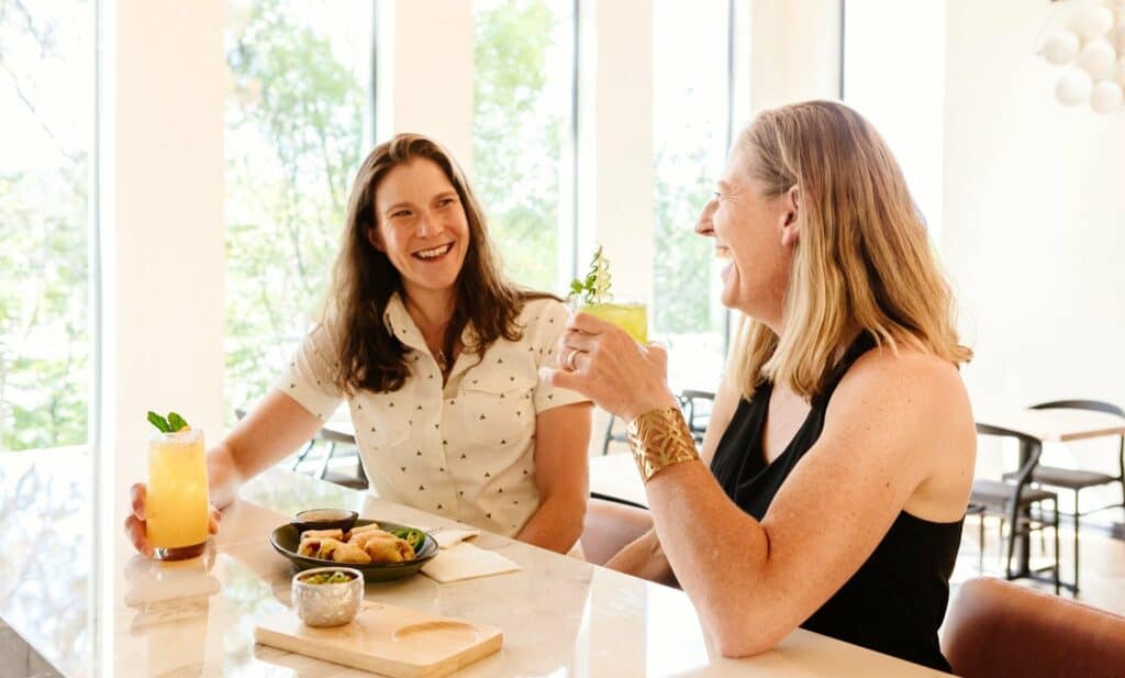 Two women enjoying drinks and appetizers at a restaurant in Central Oregon.