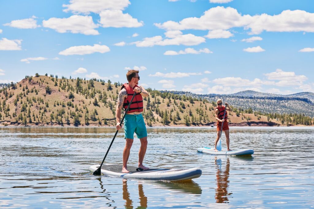 Two people paddle boarding at Prineville Reservoir State Park.