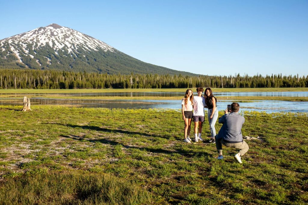Family posing for photographs in front of Mount Bachelor near Bend, Oregon