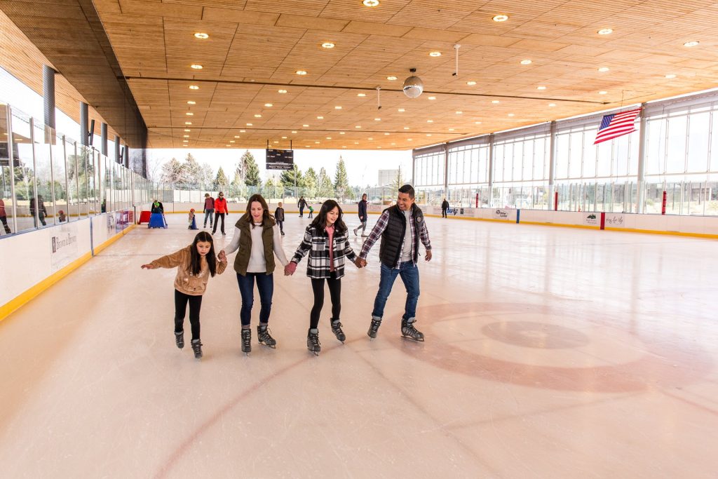 A family enjoys ice skating together in an indoor rink in Central Oregon.