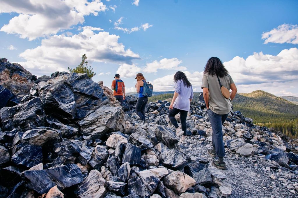 Hikers at Big Obsidian Flow in the Newberry National Volcanic Monument near La Pine, Oregon