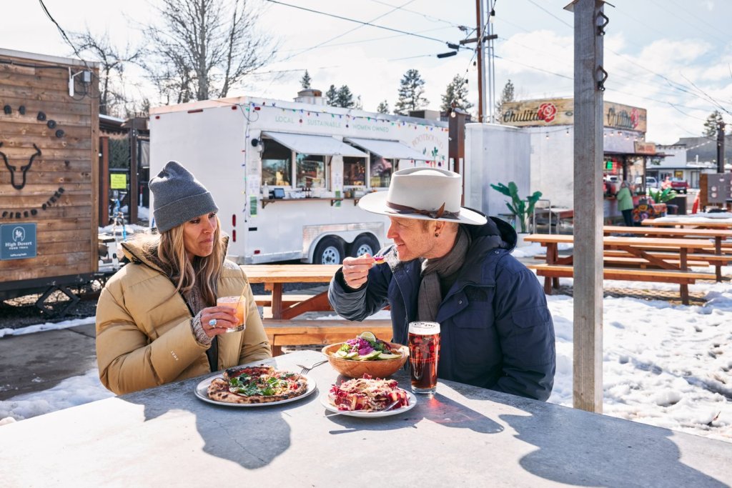A couple enjoying food and drink at The Barn in Sisters, Oregon