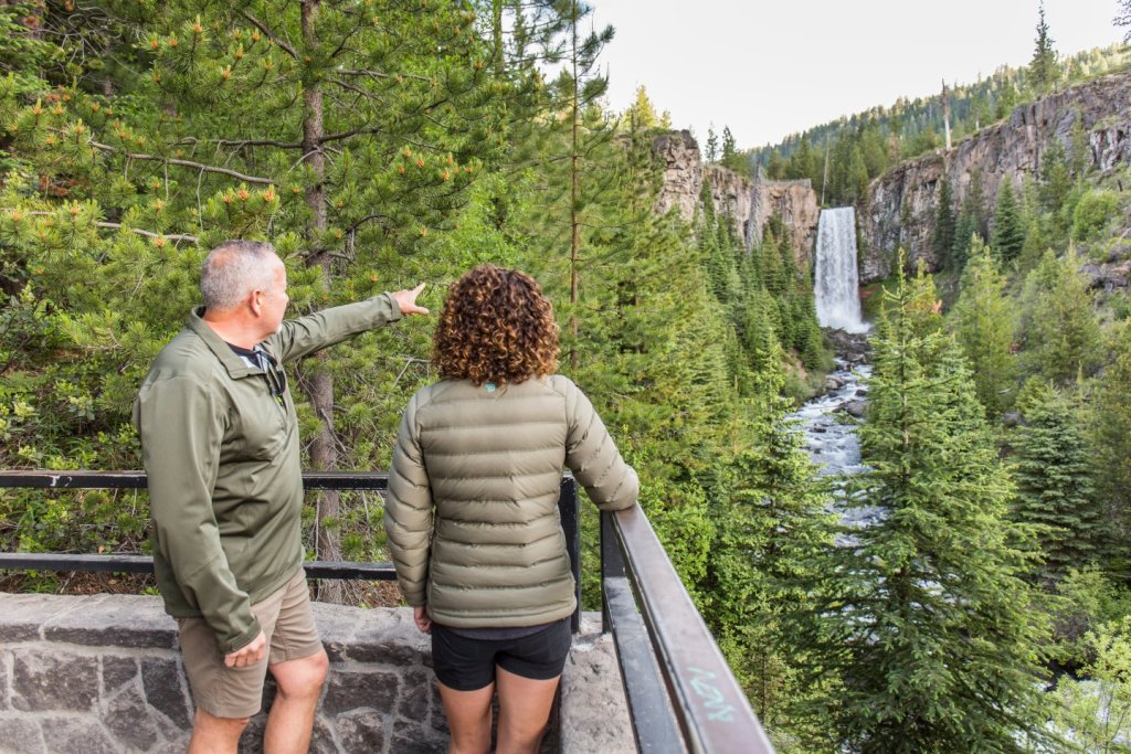 Hikers at a viewpoint overlooking Tumalo Falls near Bend, Oregon