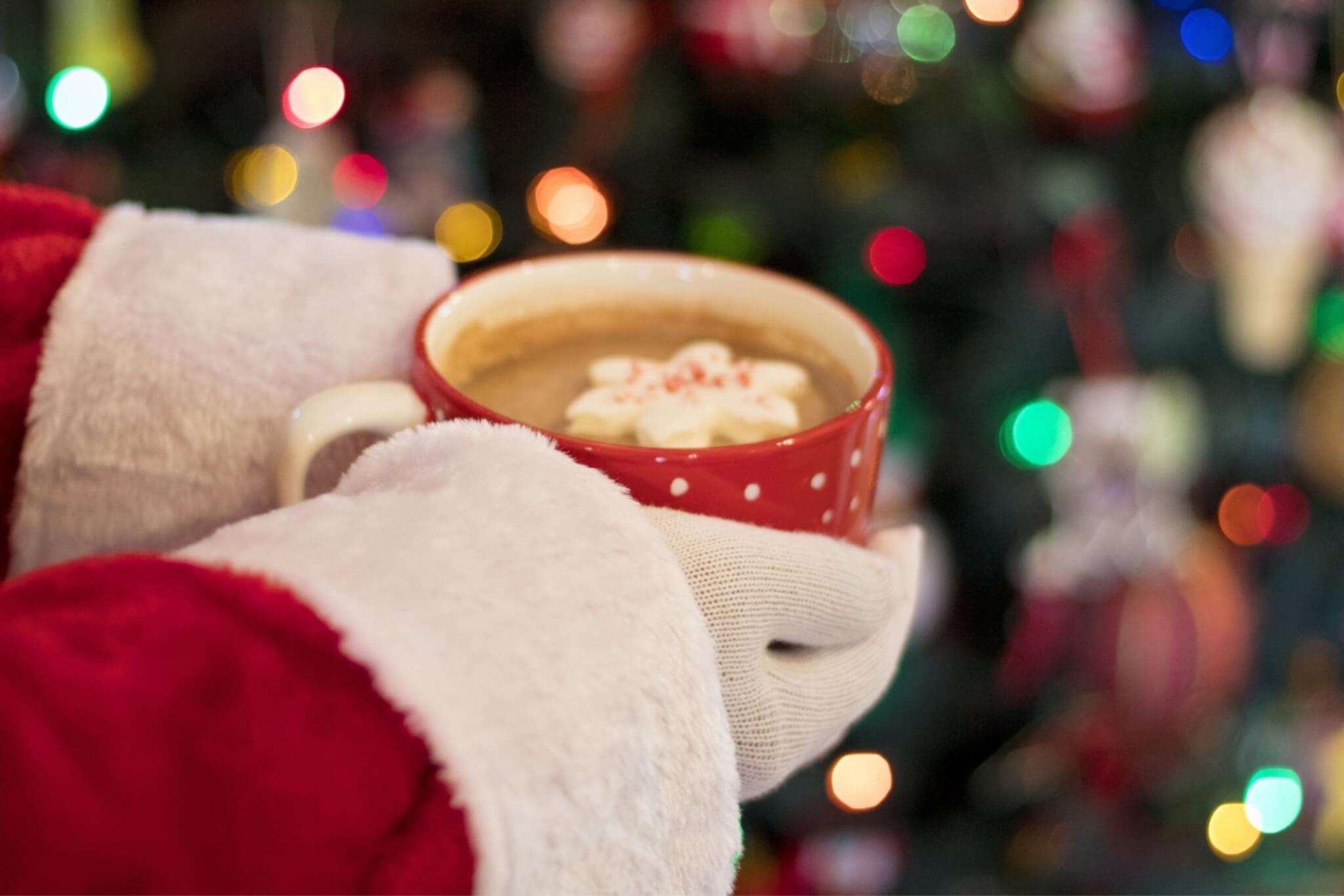 Santa Claus holding a festive mug of hot chocolate, surrounded by Christmas decorations in Central Oregon.