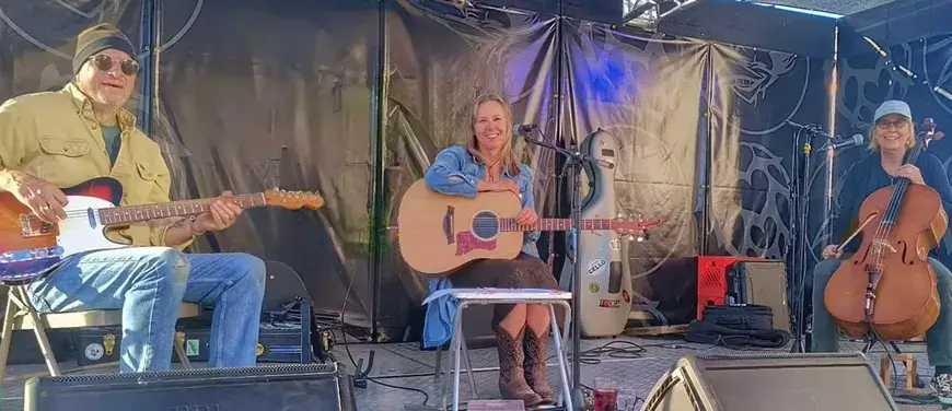 A lively musical performance featuring three musicians on stage in Central Oregon.