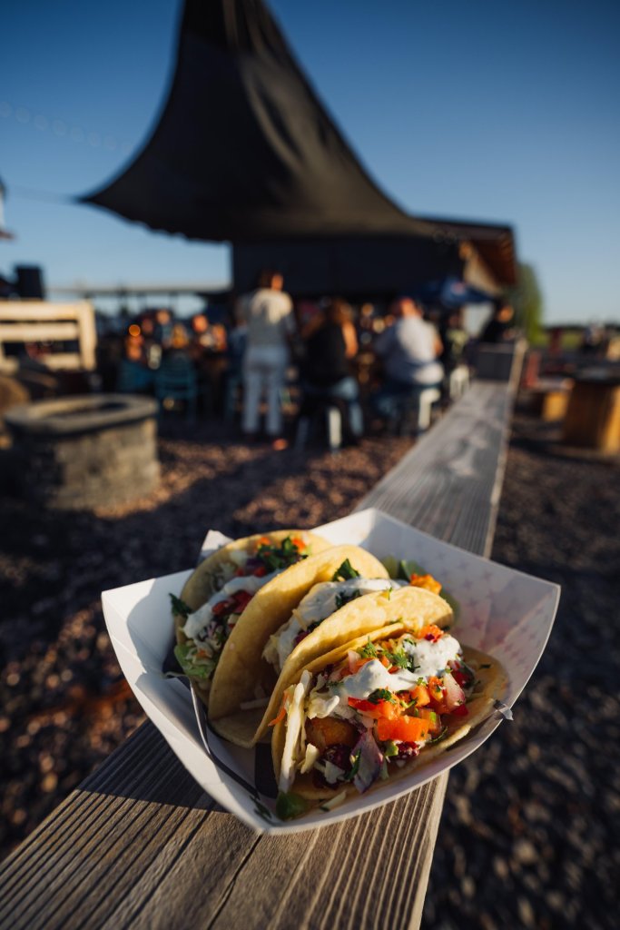 Three tacos filled with fresh ingredients, served on a wooden table in Central Oregon.