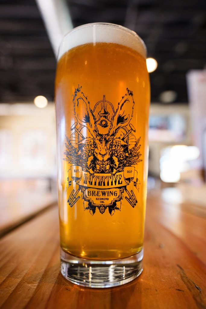 A glass of amber beer with intricate black design featuring a rabbit and botanical elements in Central Oregon.