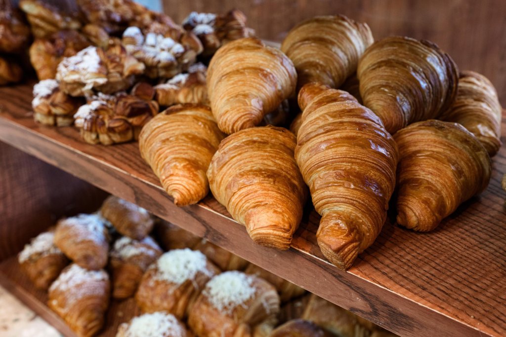 A display of freshly baked croissants and pastries on a wooden shelf in Central Oregon.
