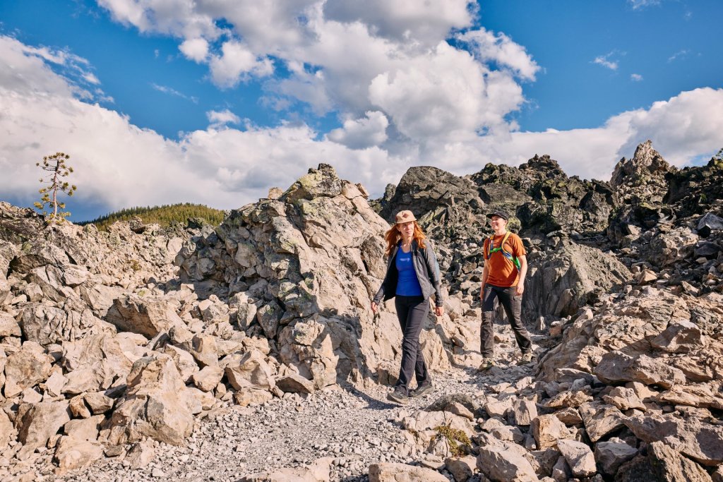 Two hikers explore a rocky trail through a rugged landscape in Central Oregon.