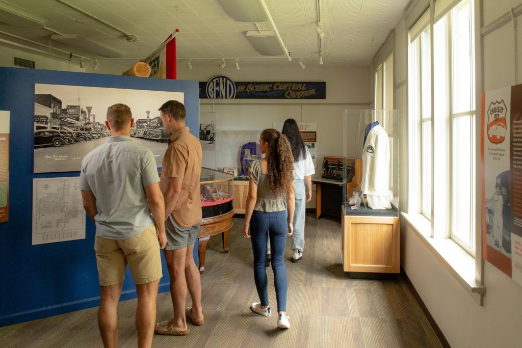 Visitors examine historical exhibits in a museum dedicated to Bend, Oregon's scenic central history in Central Oregon.