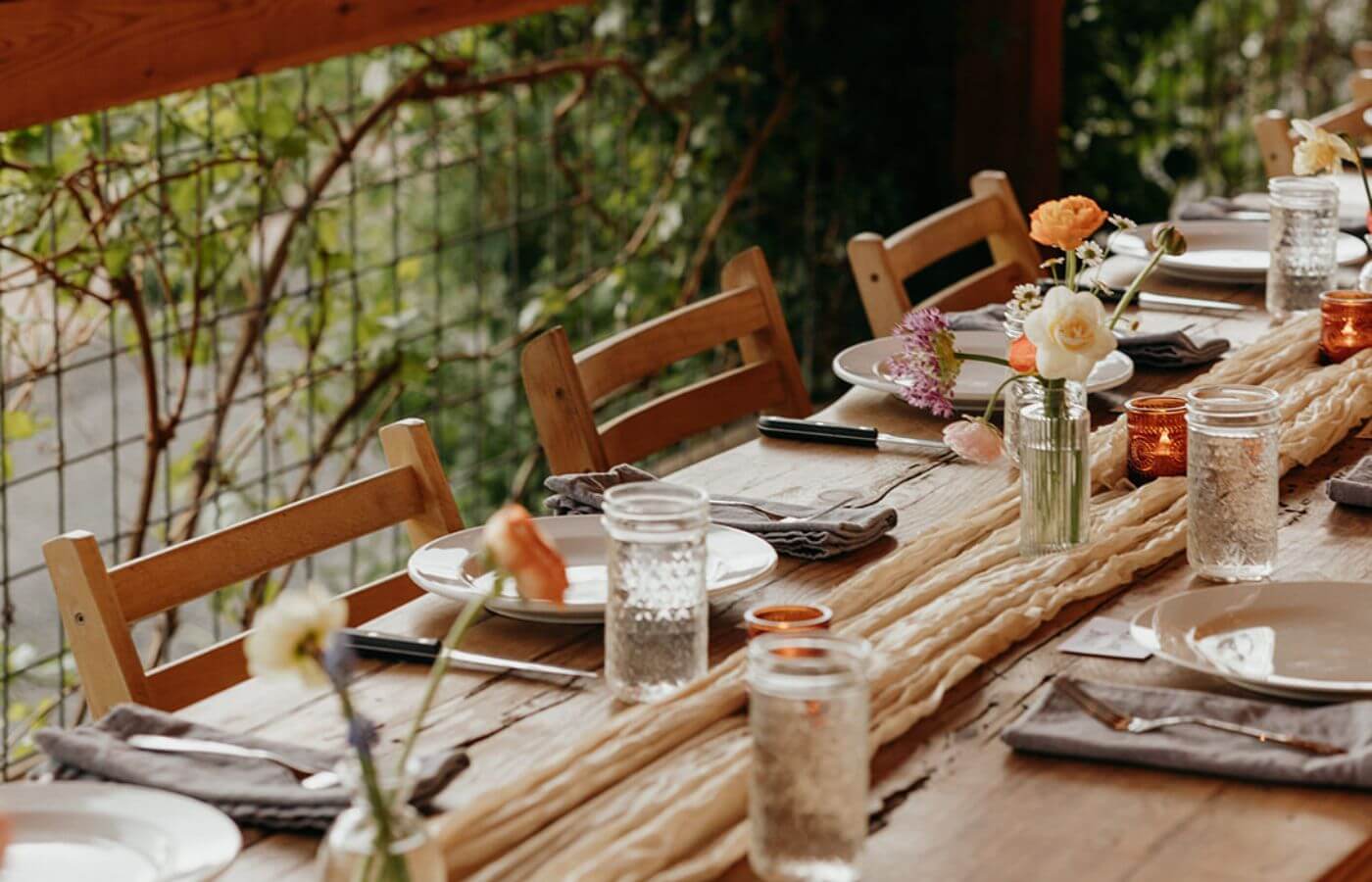 Rustic wooden table set for a charming outdoor dinner with flowers and candles in Central Oregon.