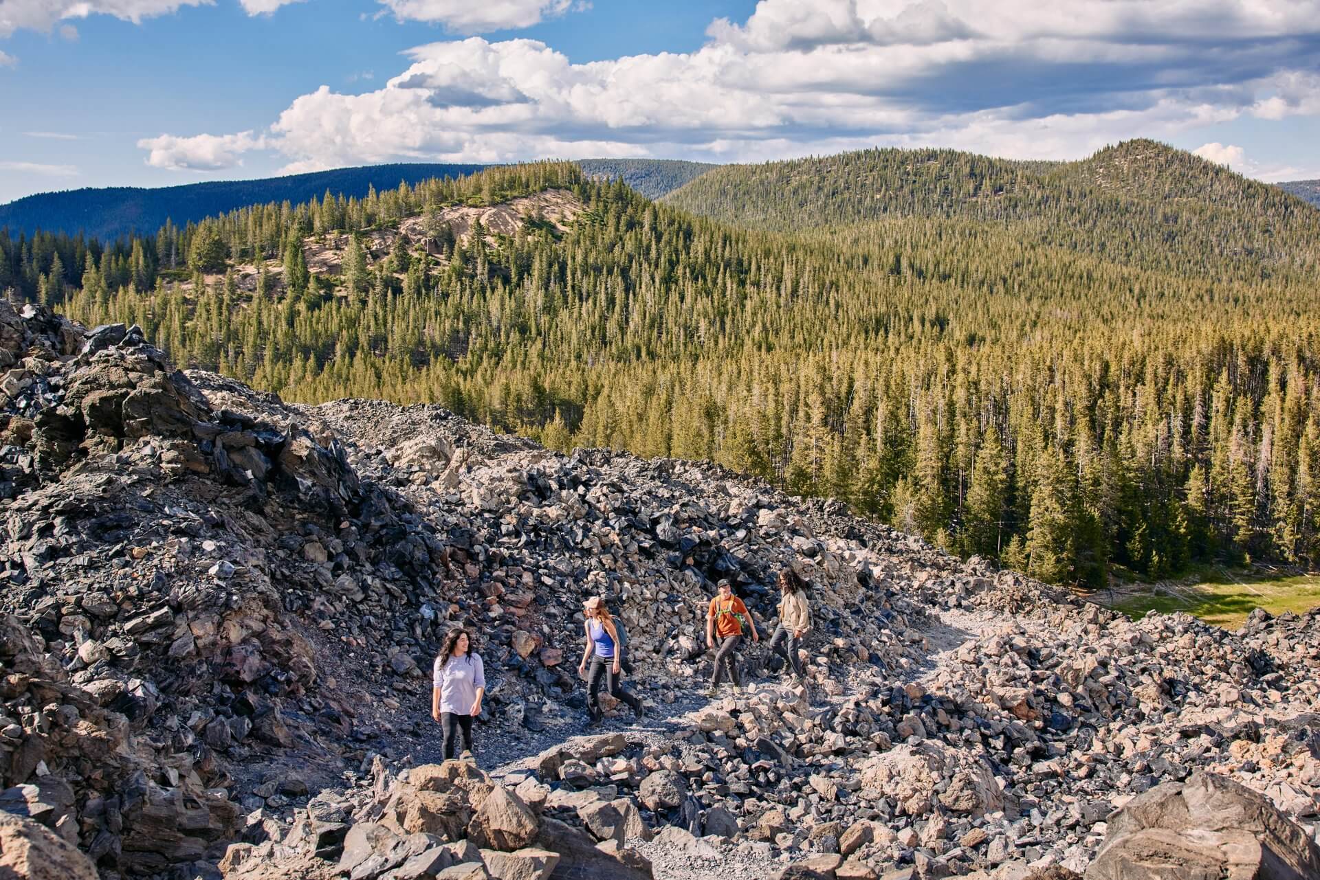 Group of friends hikes through lava fields at Newberry National Monument near Sunriver, Oregon