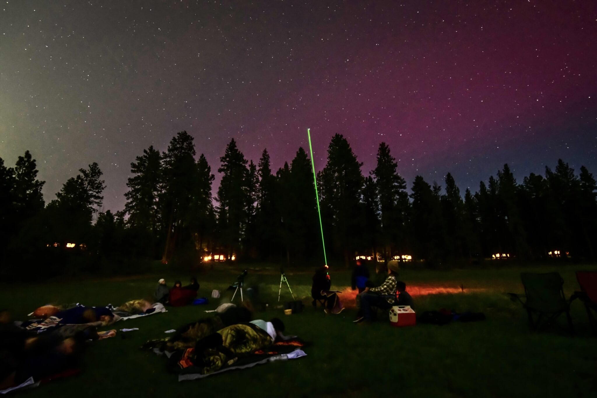 A group of people gathered outdoors at night, stargazing and enjoying the night sky in Central Oregon.