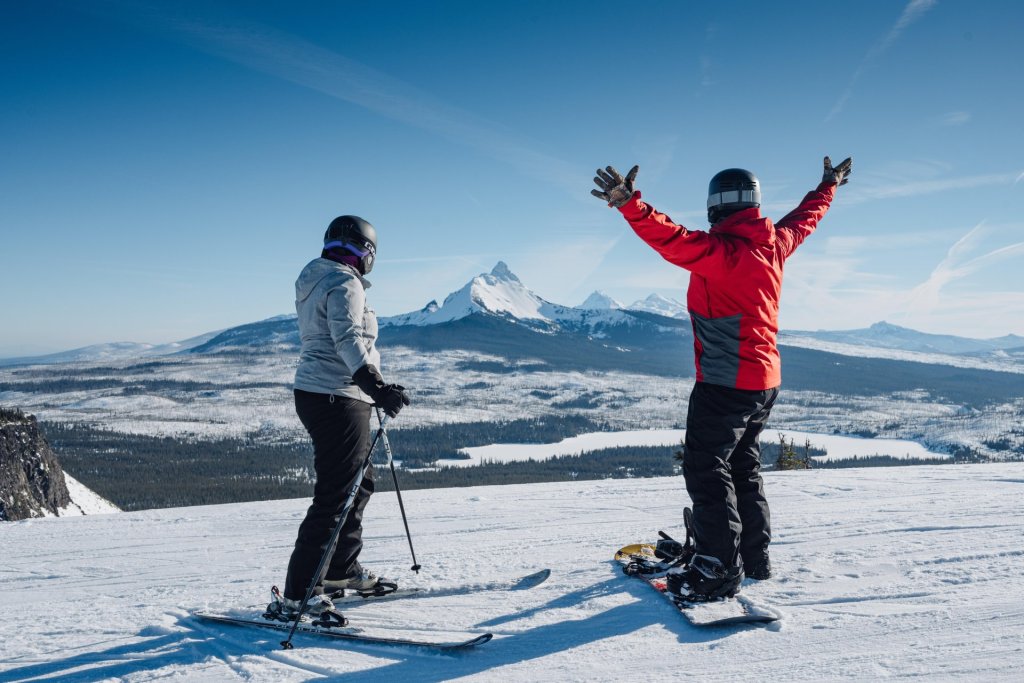 Skier and snowboarder at Hoodoo Ski Area near Sisters, Oregon, with Mt. Washington in the background