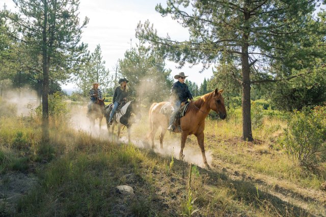 Three cowboys ride horses through a misty forest, kicking up dust in Sunriver, Oregon.