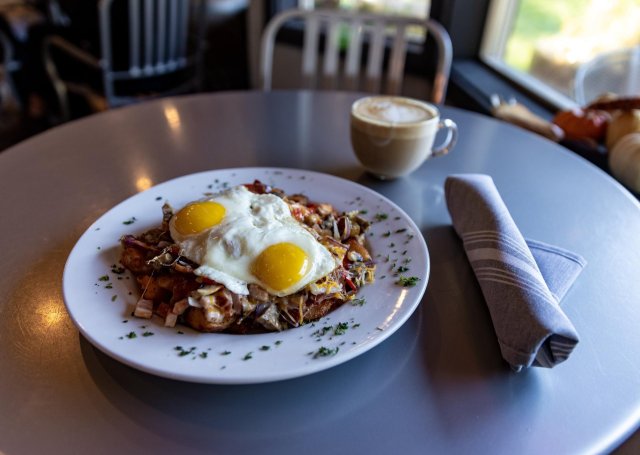 A hearty breakfast dish with two sunny-side-up eggs over a bed of potatoes and vegetables in Central Oregon.