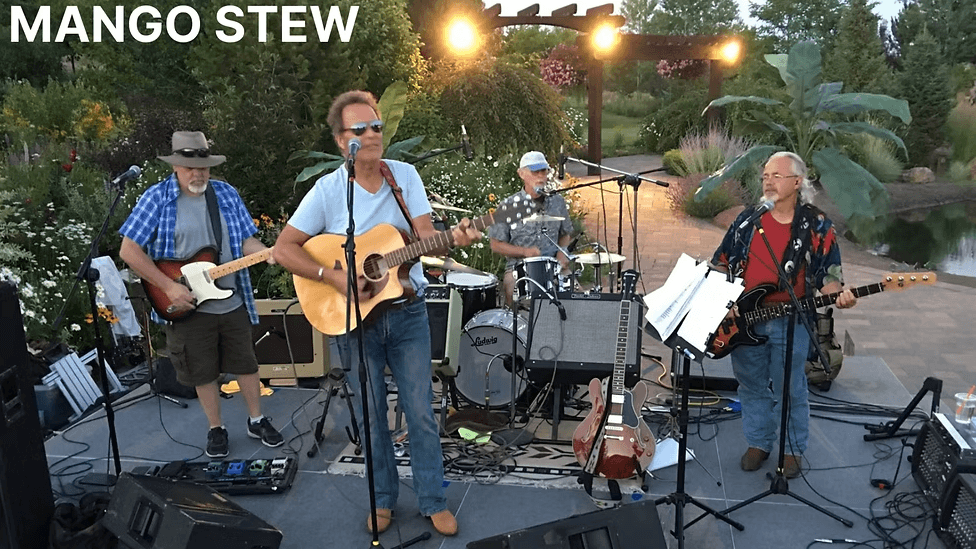 Four musicians perform outdoors, playing various instruments under a pergola with a pond nearby in Central Oregon.