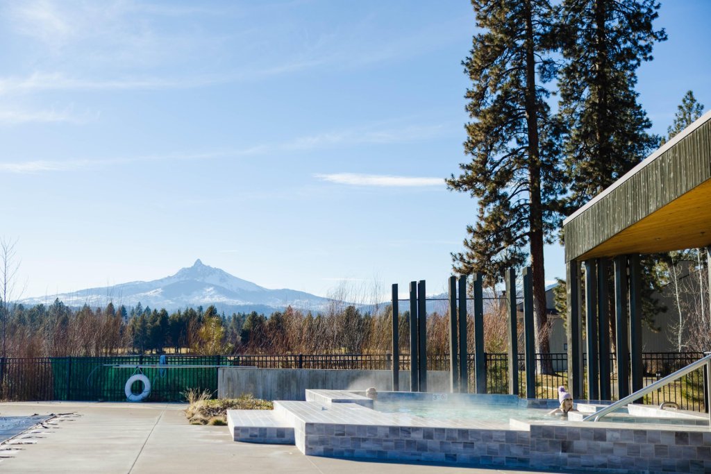 A serene hot tub area with a view of a majestic mountain range in Central Oregon.