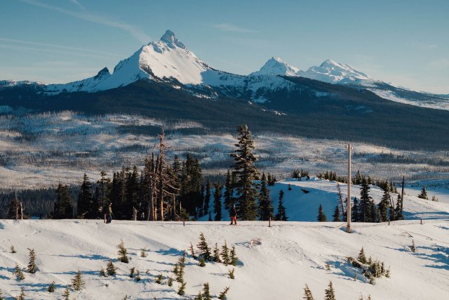 A snowy mountain landscape with a skier in the foreground in Central Oregon.