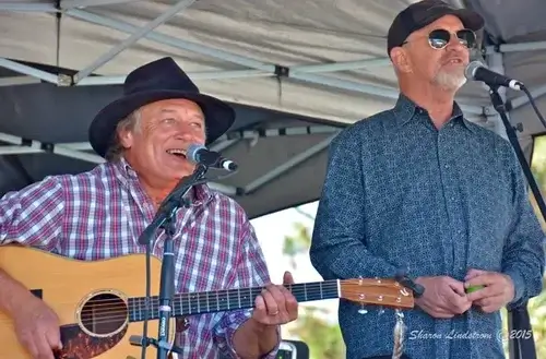 Two men perform music at a stage, one playing guitar, the other singing in Central Oregon.
