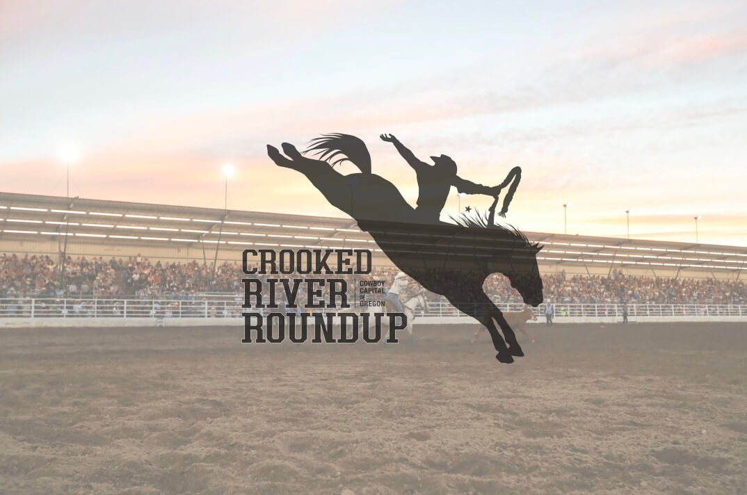 A cowboy on a bucking bronco at sunset, with the text 'Crocked River Roundup' visible in Central Oregon.