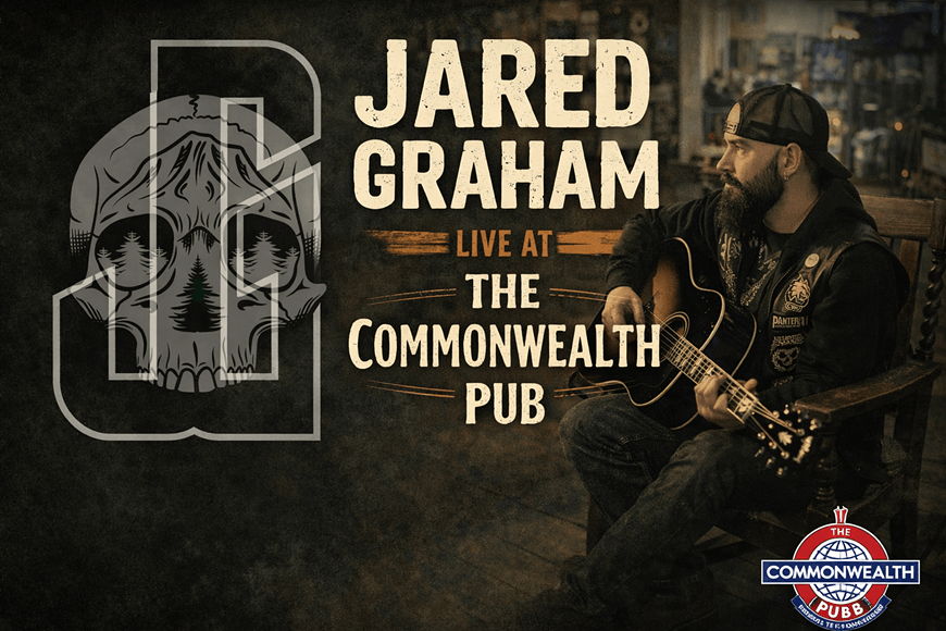 A bearded man with a guitar performs at a pub, with a stylized skull logo featuring a pine tree in the background in Central Oregon.