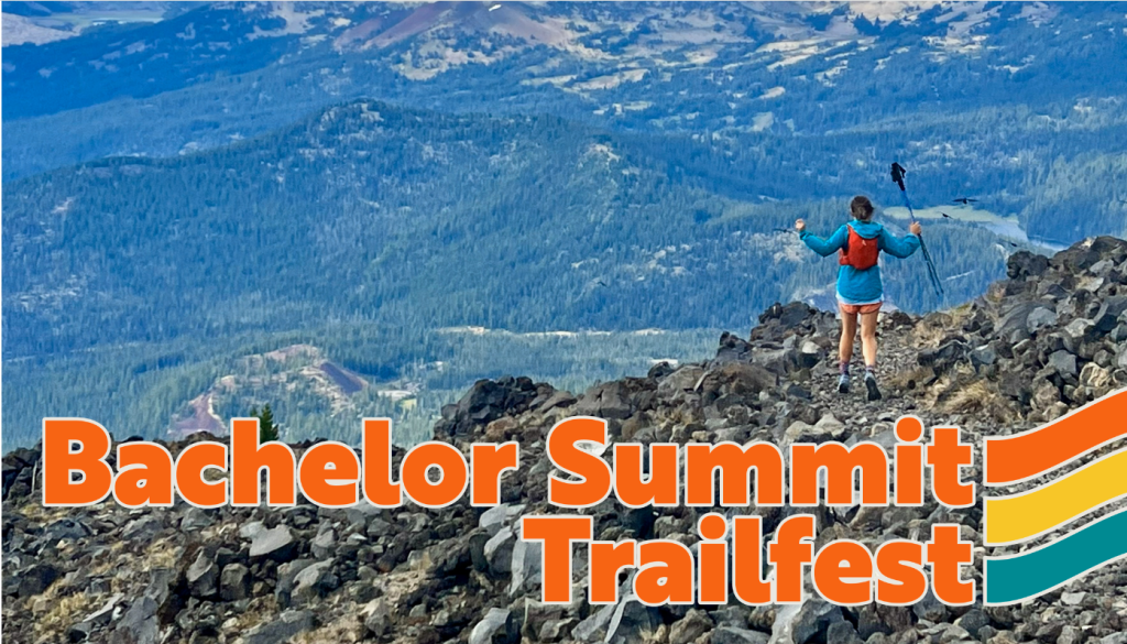 A hiker stands triumphantly on a rocky summit, overlooking a breathtaking mountain landscape at Bachelor Summit Trailfest in Central Oregon.