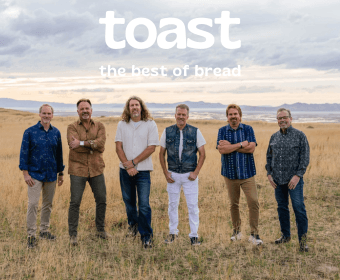 A group of six men standing in a field of tall grass with mountains in the background in Central Oregon.