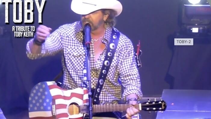 Toby Keith performs on stage with an American flag-themed guitar in Central Oregon.