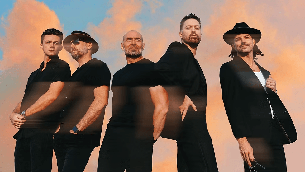 Five men dressed in black stand against a backdrop of a fiery orange and blue sky in Central Oregon.