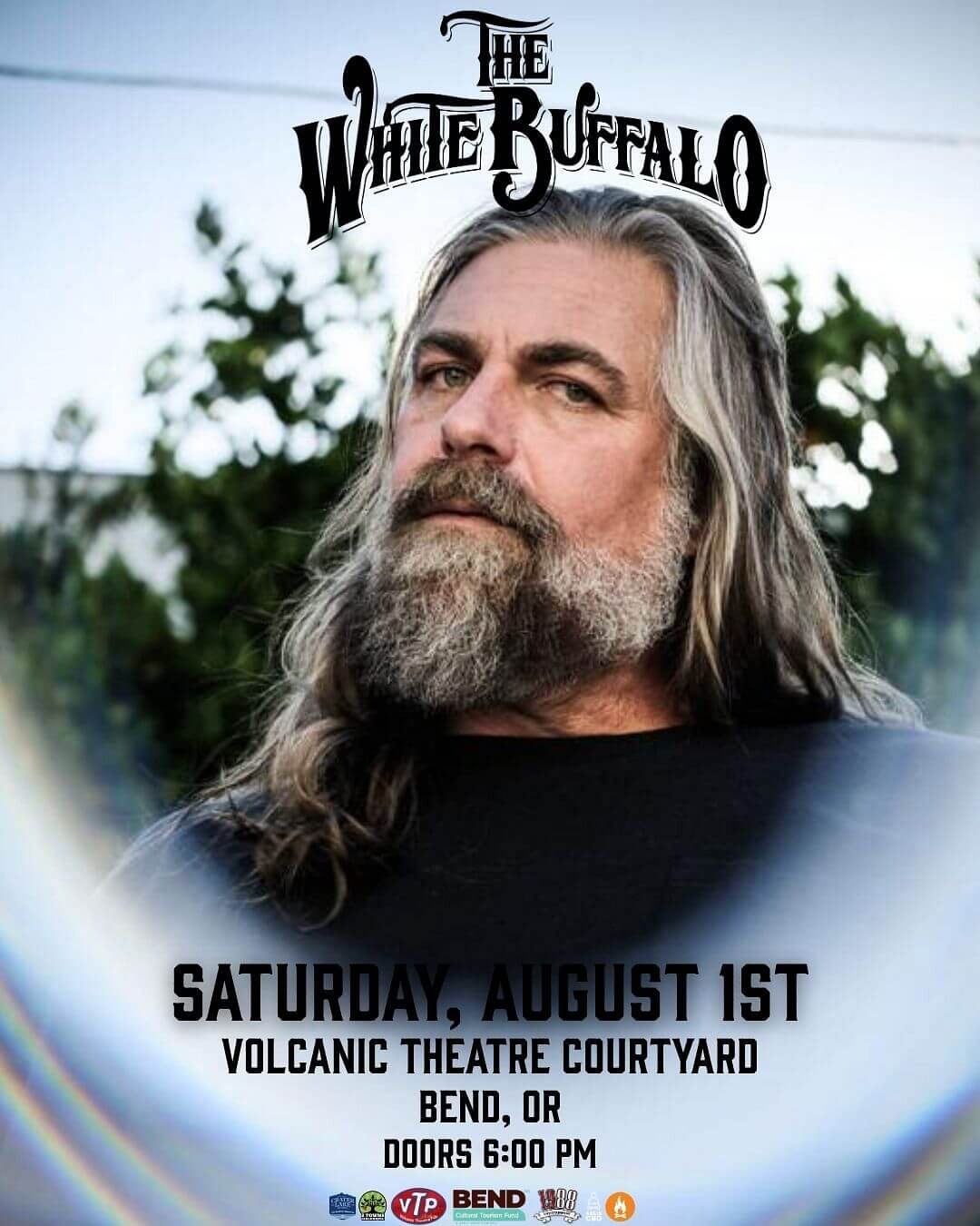 A man with long gray hair and a beard gazes thoughtfully to the side in Central Oregon.