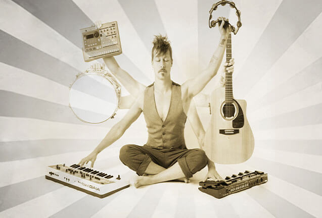 A musician meditating in a lotus position surrounded by various musical instruments in Central Oregon.