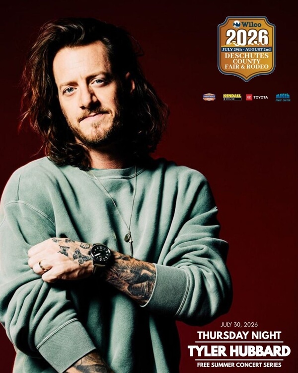 Tyler Hubbard, a country music artist, poses with his arms crossed against a red background in Central Oregon.