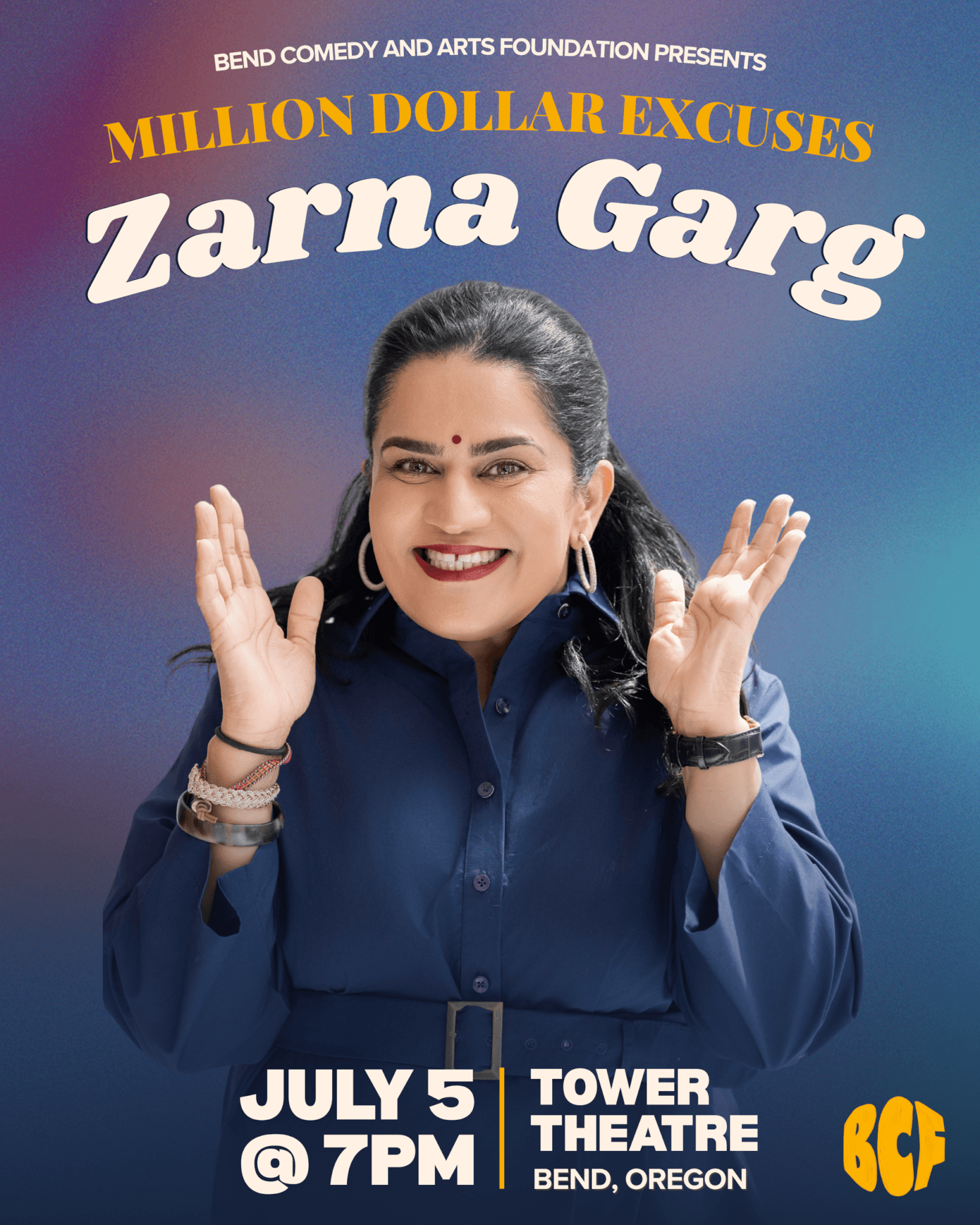 Zarna Garg, a woman with dark hair and a bindi, smiles broadly with her hands raised in excitement in Central Oregon.