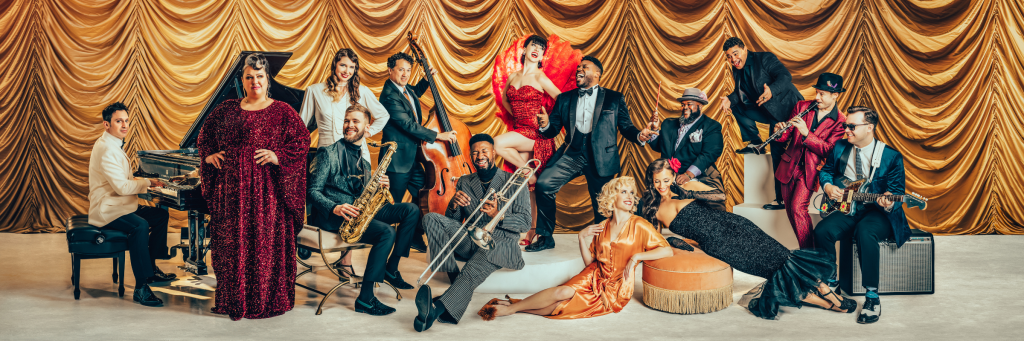A vibrant jazz ensemble in glamorous attire performs on a stage adorned with golden curtains in Central Oregon.