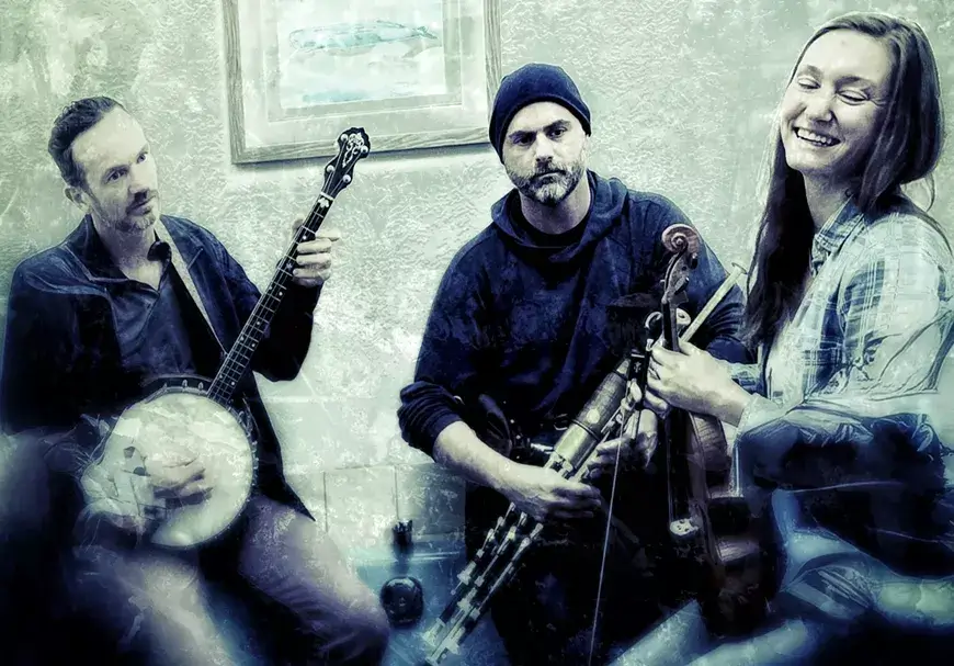 Three musicians, each holding a different string instrument, share a joyful moment together in Central Oregon.